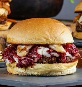 Mouthwatering capture of three gourmet burgers with diverse toppings and a side of fries.