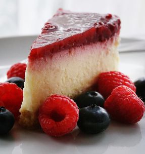 A tempting slice of cheesecake topped with berries, perfect for dessert lovers.